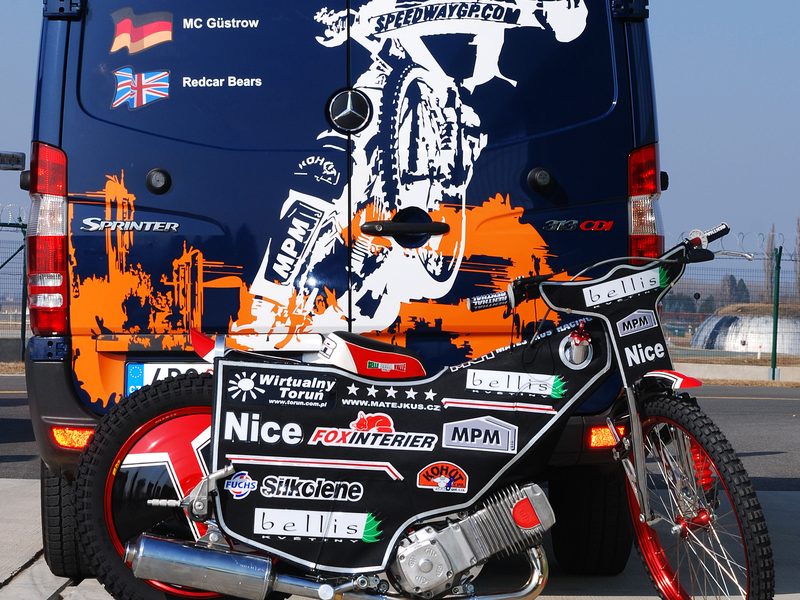 Motocykl připravený na sezonu před týmovou dodávkou s nápisem Matěj Kůs