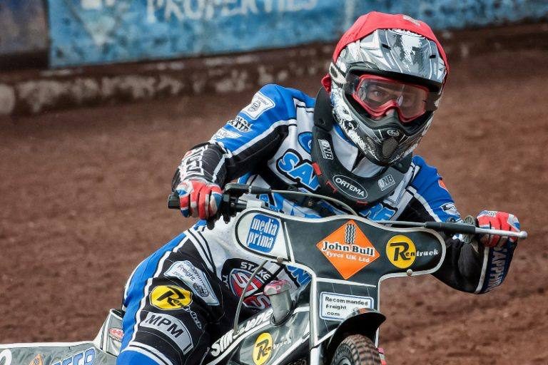Matěj Kůs v modrobílé kombinéze Newcastlu a červené přilbě vychází na motocyklu ze zatáčky